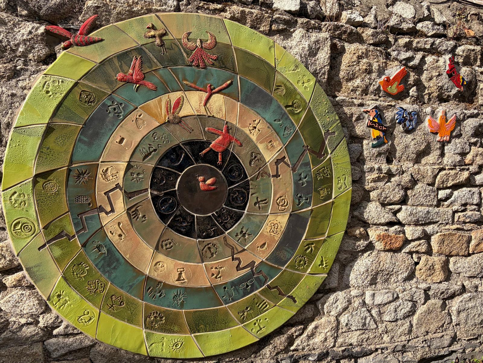 Ceramic mural at St. Declan’s School, with colourful circular tiles and birds on a stone wall
